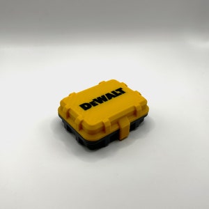 May include: A yellow plastic storage case with a black lid and the word "DEWALT" printed in black on the top.