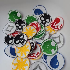 Pode incluir: Uma coleção de patches bordados em várias cores e designs. Os patches apresentam símbolos como caveiras, sóis, árvores e gotas de água, com bordas brancas. Os patches são provavelmente para roupas ou acessórios.