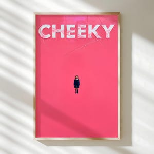 May include: Framed art print featuring the word "CHEEKY" in white, textured lettering against a vibrant pink background. A small figure in a school uniform stands below the text. The artwork is encased in a light-colored wooden frame.