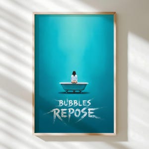 May include: Framed art print with a teal backdrop and a person seated in a teal bathtub. The white script text "Bubbles Repose" is below the tub. The frame is a light wood colour.