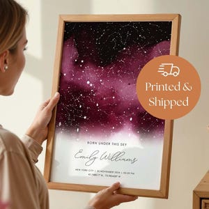 May include: A framed vertical star map print featuring a deep burgundy and black watercolor nebula background with white constellations. The text reads BORN UNDER THIS SKY, Emily Williams, and New York City, 30 November 2024, 05:39 PM.