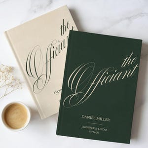 May include: Two hardback books, one cream and one dark green, with the title "the Officiant" in elegant script. The green book includes the names "Daniel Miller", "Jennifer & Lucas", and the date "07/24/26". A cup of coffee sits nearby.