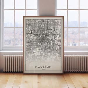 May include: A black and white map print of Houston, Texas, in a wooden frame. The map shows the city's streets and landmarks.