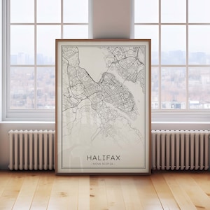 May include: A black and white map print of Halifax, Nova Scotia, framed in a light wood frame. The map is on a white background and shows the city's streets and waterways.