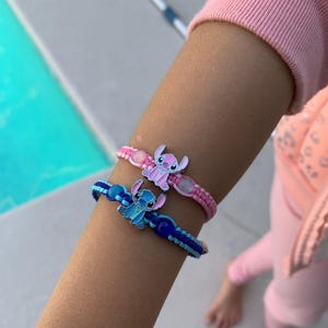 Puede incluir: Dos pulseras de la amistad con cuerda azul y rosa y un dije de personaje de dibujos animados. Los dijes son de Stitch de la pel&iacute;cula de Disney Lilo & Stitch.