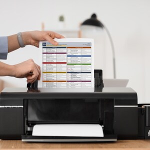 Close-up print mockup of the Python Cheat Sheet printable PDF entering a desktop printer. The image highlights the physical study potential of the printable reference pages for coding practice, revision sessions, and offline learning.