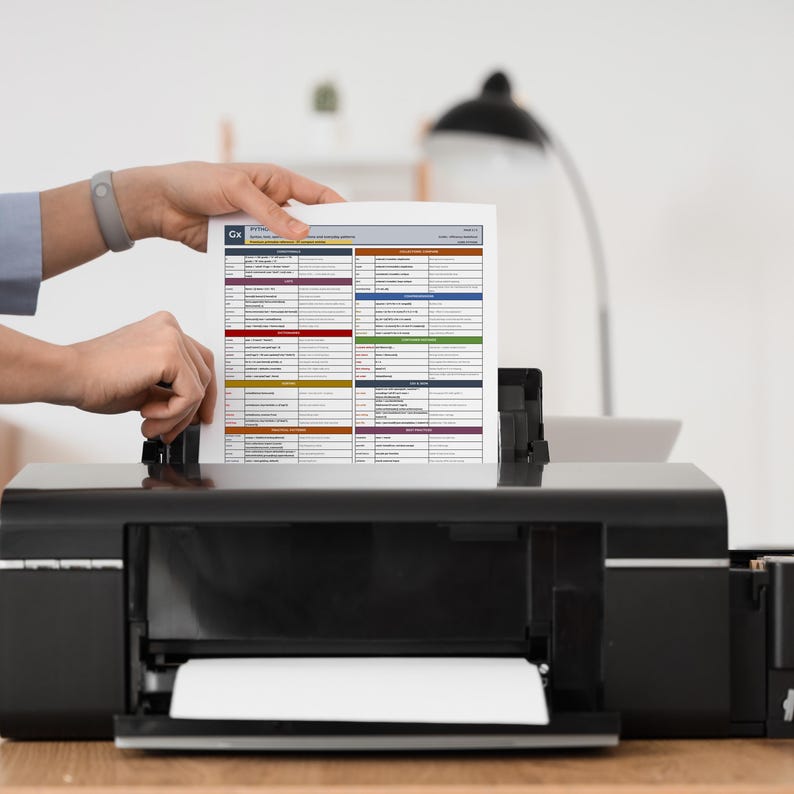 Close-up print mockup of the Python Cheat Sheet printable PDF entering a desktop printer. The image highlights the physical study potential of the printable reference pages for coding practice, revision sessions, and offline learning.