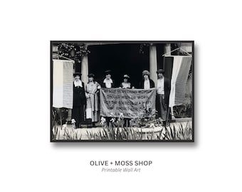 May include: A black and white photograph of six individuals standing in a row holding a banner that reads: NO SELF RESPECTING WOMAN SHOULD WISH OR WORK FOR THE SUCCESS OF A PARTY THAT IGNORES HER SEX. SUSAN B. ANTHONY 1872. They are flanked by two vertical banners.