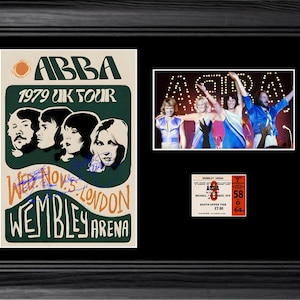 Op de afbeelding: Een zwart ingelijste display met een ABBA 1979 UK Tour-poster inclusief handtekeningen, een kleurenfoto van de band tijdens een optreden en een replica van een concertkaartje voor de Wembley Arena van 7 november 1979 op een zwarte achtergrond.