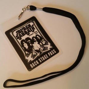 May include: Black and white backstage pass with a black lanyard. The pass features a graphic of the band Black Sabbath with the text "World Tour 1973" and "Back Stage Pass".