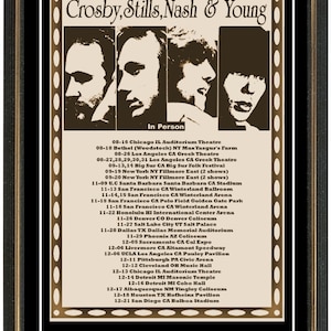 Könnte beinhalten: Ein Vintage-Konzertplakat für die Tour von Crosby, Stills, Nash & Young aus dem Jahr 1969. Das Plakat zeigt ein Schwarzweißbild der Bandmitglieder und eine Liste der Tourdaten und -orte. Das Plakat ist in einem schwarzen Rahmen mit goldener Verzierung gerahmt.