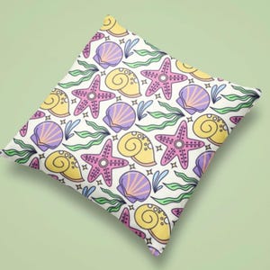 Almofada para área externa com estampa de conchas e estrelas-do-mar, design inspirado em conchas de praia.