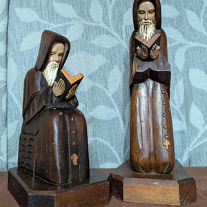 Dos esculturas de arte popular de la década de 1950 que representan a monjes cristianos leyendo