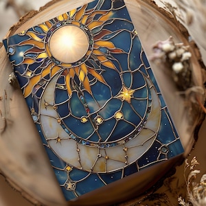 May include: A stained glass notebook cover with a sun and moon design. The sun is yellow and orange with a bright center. The moon is white with a gold outline. The background is blue with gold stars.
