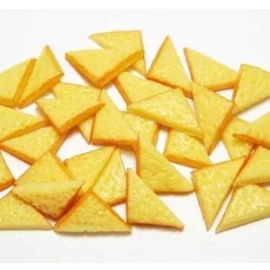 May include: A large pile of small, yellow, triangular-shaped crackers.