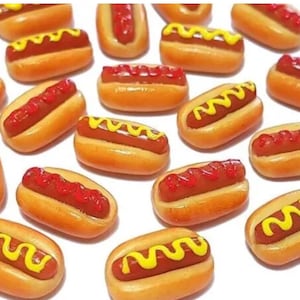 Op de afbeelding: Een verzameling miniatuur hotdogs met gele mosterd en rode ketchup topping. De hotdogs zijn gemaakt van polymer clay en zijn perfect voor poppenhuizen of miniatuur voedsel displays.