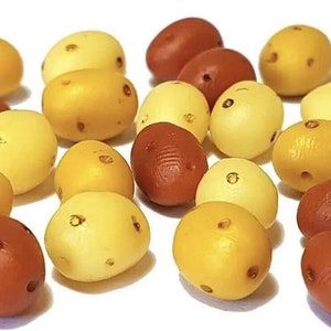 May include: A collection of small, hand-painted, ceramic potatoes in various shades of yellow, orange, and brown.