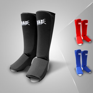 May include: A pair of black shin guards with white "RADIX" branding, shown with a pair of red and a pair of blue shin guards.