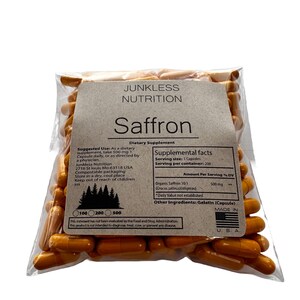 May include: A clear plastic bag filled with orange capsules, labeled "Junkless Nutrition Saffron." The label includes supplement facts, ingredients, and usage instructions. The capsules are a dietary supplement, with 500 mg of Organic Saffron 10:1 per serving.