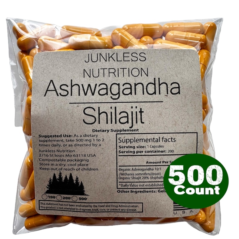 May include: A clear plastic bag filled with orange capsules. The bag has a label with the text "Junkless Nutrition Ashwagandha Shilajit Dietary Supplement." A green circle on the bag reads "500 Count."