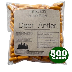 May include: A transparent bag containing numerous orange capsules. The label displays "JUNKLESS NUTRITION Deer Antler Dietary Supplement." A green circle indicates a 500-count package. The capsules are a dietary supplement.