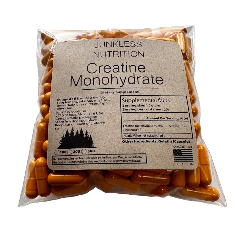 Puede incluir: Una bolsa de pl&aacute;stico transparente llena de c&aacute;psulas de monohidrato de creatina de color naranja. La bolsa tiene una etiqueta marr&oacute;n con el texto "Junkless Nutrition Creatine Monohydrate" e informaci&oacute;n nutricional. La etiqueta tambi&eacute;n incluye "Made in U.S.A."