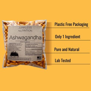 May include: A transparent bag filled with orange capsules, labelled "Ashwagandha" by Junkless Nutrition. The bag has a brown paper label with supplement facts and the text "Plastic Free Packaging, Only 1 Ingredient, Pure and Natural, Lab Tested."