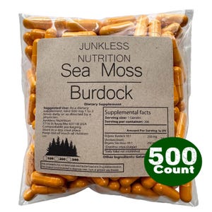 Puede incluir: Una bolsa de plástico transparente llena de cápsulas naranjas. La etiqueta dice "Junkless Nutrition Sea Moss Burdock" e incluye información sobre suplementos. Un círculo verde indica un paquete de 500 cápsulas.