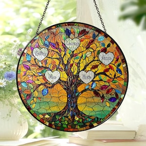 May include: A stained glass window hanging with a colorful mosaic tree design. The tree has five hearts with names written inside: "Sofia", "Liana", "Vira", "Nato", and "Anna".
