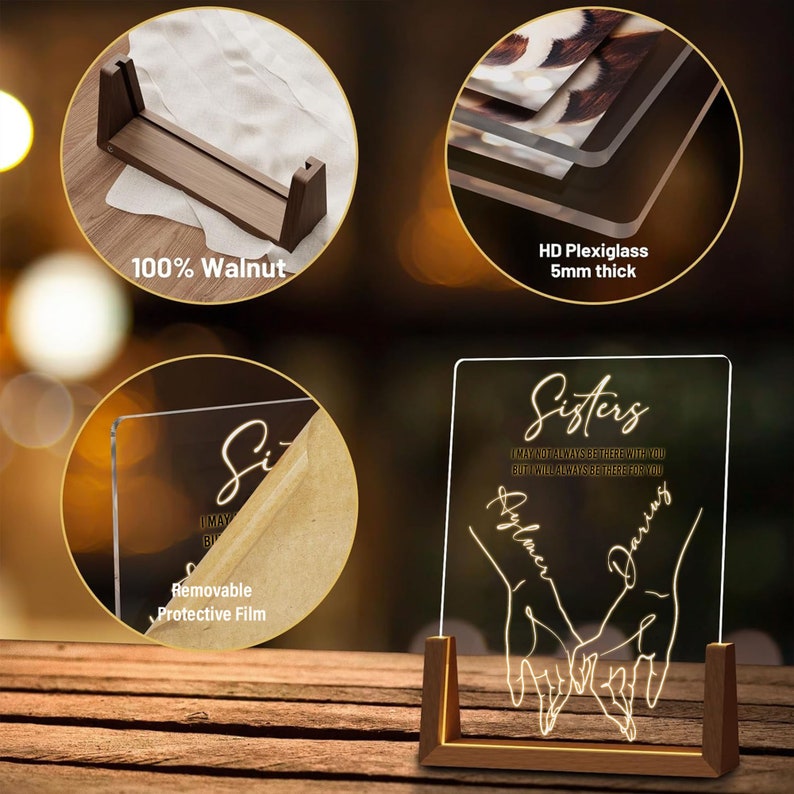 May include: A personalised acrylic light-up sign with a wooden base. The sign features the word "Sisters" with a quote about always being there for each other. The names "Ayla" and "Daring" are written in cursive below the quote. The sign is illuminated with a warm white light.
