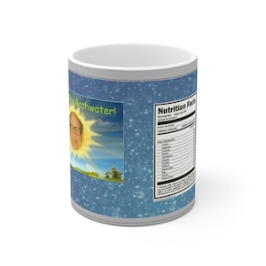 Puede incluir: Taza de cerámica blanca con fondo azul y un sol de dibujos animados con cara de hombre. El texto "Sunshine Bathwater!" está impreso en la taza. La parte posterior de la taza tiene una etiqueta de información nutricional con una lista humorística de ingredientes.