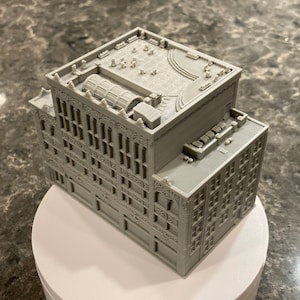 May include: A detailed gray 3D printed model of a building with ornate details and a rooftop terrace.