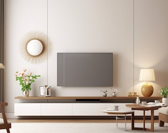 May include: A modern living room with a white wall, a flat screen TV, a white entertainment center, a wooden coffee table, and a lamp with a white shade and a gold base.