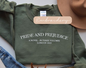 Puede incluir: Una sudadera verde con bordado blanco que dice "Pride and Prejudice, A Novel - In Three Volumes, London 1813".