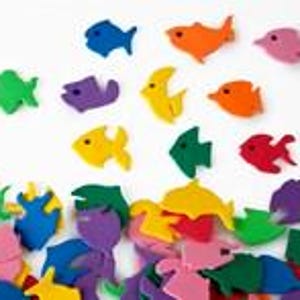 May include: A collection of colorful felt fish in various shapes and sizes. The fish are in shades of blue, green, orange, yellow, purple, and pink. Some fish are scattered, while others are clustered together, all against a white background.