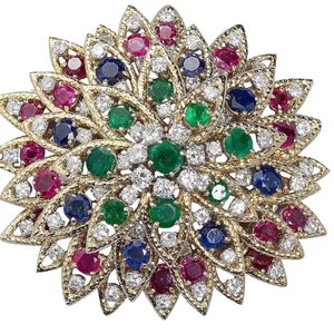 Könnte beinhalten: Eine goldene Brosche mit einem floralen Design mit Rubinen, Smaragden, Saphiren und Diamanten.