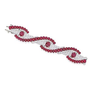 May include: A white gold bracelet with a wave-like design set with rubies and diamonds.
