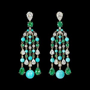 May include: A pair of dangle earrings with a cascade of turquoise, emerald green, and clear stones. The earrings are gold-toned and feature a large, round turquoise stone at the bottom.