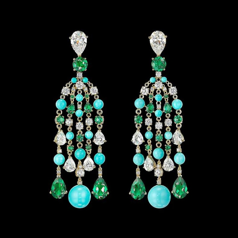 May include: A pair of dangle earrings with a cascade of turquoise, emerald green, and clear stones. The earrings are gold-toned and feature a large, round turquoise stone at the bottom.