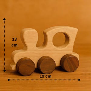 May include: A wooden toy train with brown wheels and a light brown body. The train is 13 cm tall and 19 cm long.