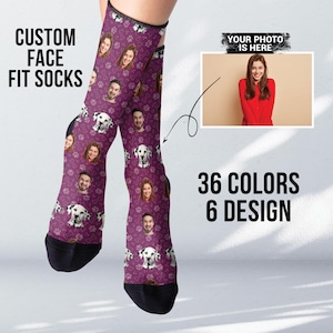 May include: Purple socks with a custom face design. The socks feature a repeating pattern of faces and dogs. The text "CUSTOM FACE FIT SOCKS" is at the top of the image. The text "YOUR PHOTO IS HERE" is at the top right of the image. The text "36 COLORS 6 DESIGN" is at the bottom of the image.