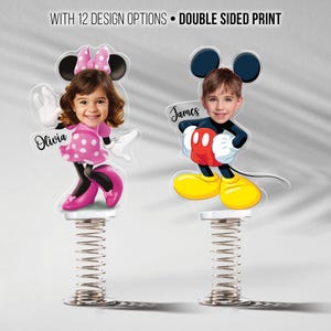 May include: Two personalized spring toys featuring Mickey and Minnie Mouse designs. Each toy has a child's face and name. The Minnie Mouse toy is pink with white polka dots, and the Mickey Mouse toy has a red shirt and yellow shoes. The text reads: WITH 12 DESIGN OPTIONS • DOUBLE SIDED PRINT.