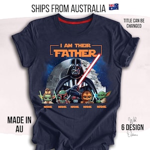 May include: Dark blue t-shirt with a graphic of Darth Vader holding a red lightsaber, the words "I AM THEIR FATHER", and cartoon characters. The shirt has a red neckline and the text "NAME" below the characters.