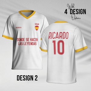 May include: White soccer jersey with yellow trim and red accents. The front of the jersey has the text "#EURO2024", "SPAIN", and "DONDE SE HACEN LAS LEYENDAS". The back of the jersey has the text "RICARDO" and the number "10".