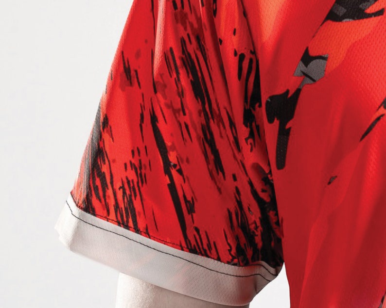 May include: Red and black patterned short-sleeved shirt with a white trim around the sleeve.