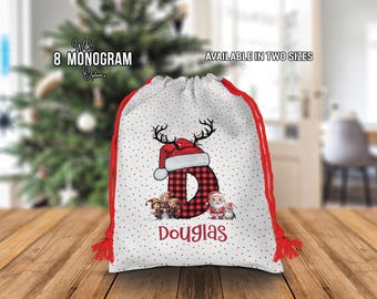 May include: White Christmas gift bag with red trim and a red and black plaid reindeer with a Santa hat. The bag has white polka dots and the name "Douglas" printed on it.