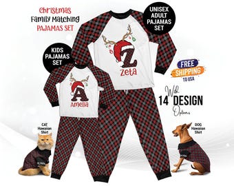 Könnte beinhalten: Passende Familienpyjamas mit einem rot-schwarzen Karomuster. Der Pyjama für Erwachsene hat ein weißes Langarmshirt mit einer rot-weißen Weihnachtsmütze und dem Buchstaben Z. Der Pyjama für Kinder hat ein weißes Langarmshirt mit einer rot-weißen Weihnachtsmütze und dem Buchstaben A. Die Texte "zeta" und "Amelia" sind auf den Shirts gedruckt.