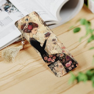 May include: A bookmark featuring a woman in a black dress with floral details, holding a teacup. The background is a watercolor-style painting with a vintage aesthetic.