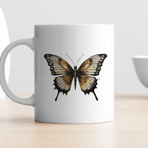 Puede incluir: Taza de cer&aacute;mica blanca con una ilustraci&oacute;n de mariposa marr&oacute;n y negra.