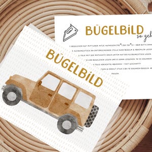 Könnte beinhalten: Ein Bügelbild im Aquarellstil mit einem braunen Jeep mit schwarzen Rädern und dem Wort "BÜGELBILD" in Gold. Anweisungen sind auf einer weißen Karte gedruckt, alles auf einem geflochtenen Korb.